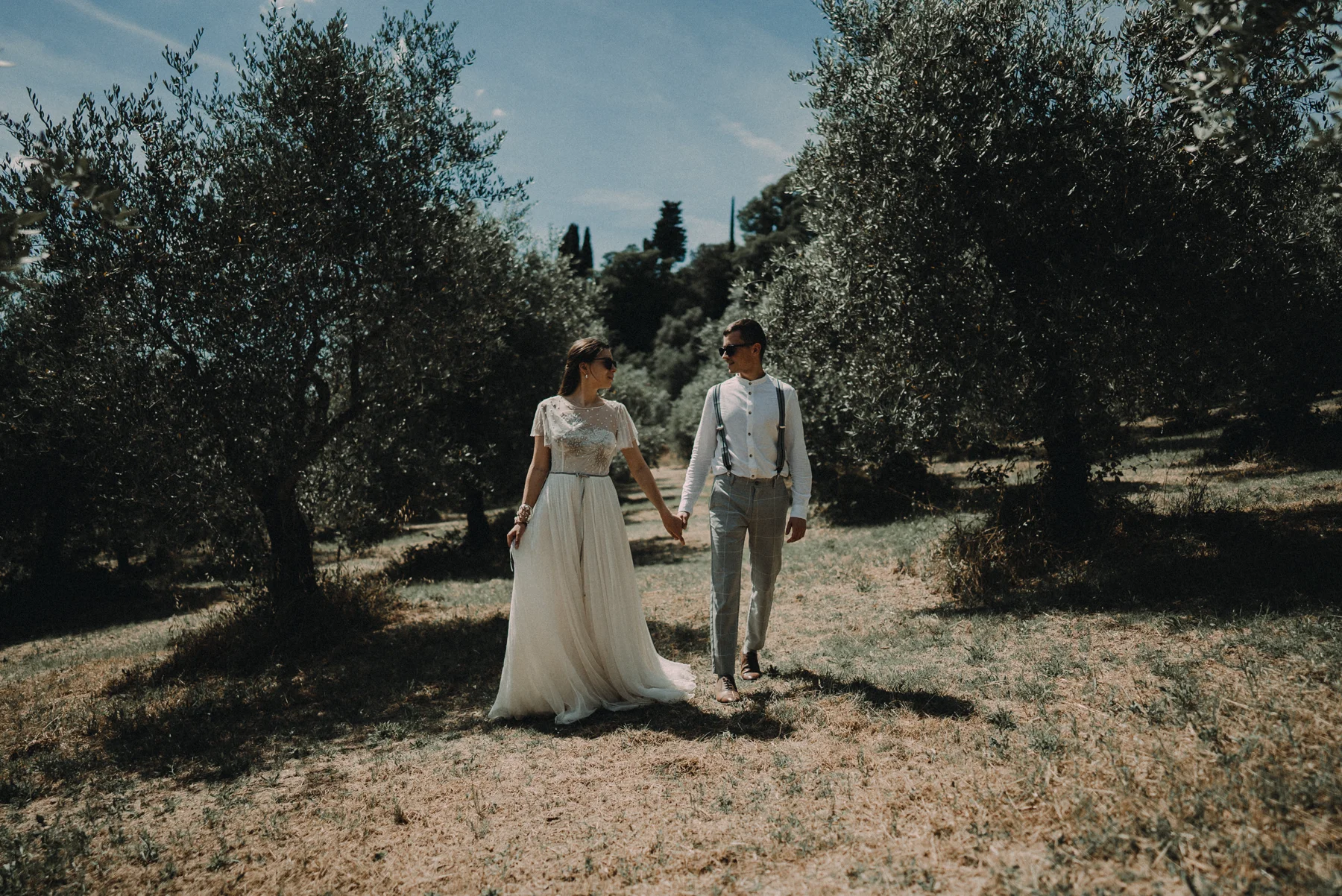Couple walking through an olive grove in Tuscany
