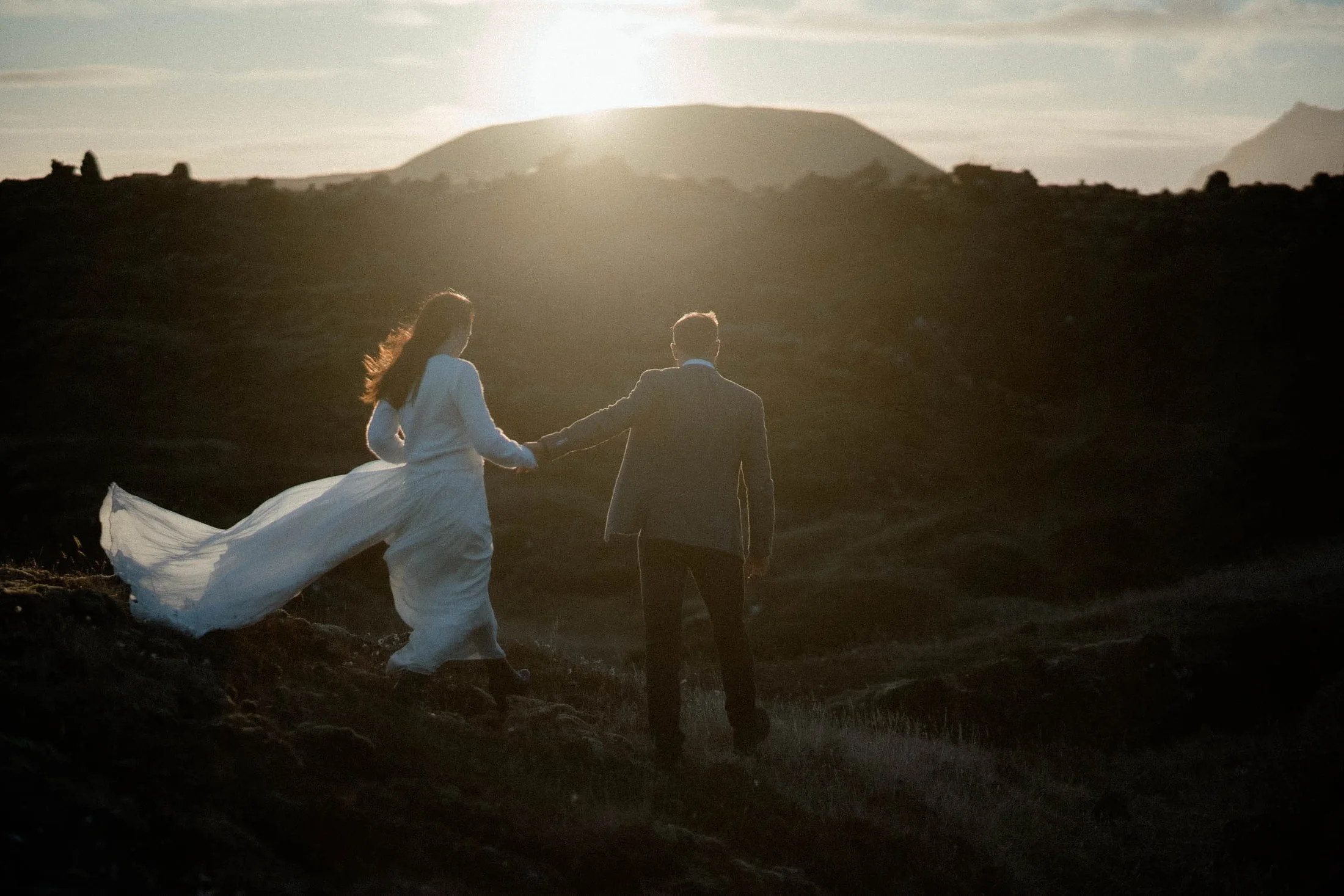Couple running through the golden light of Iceland