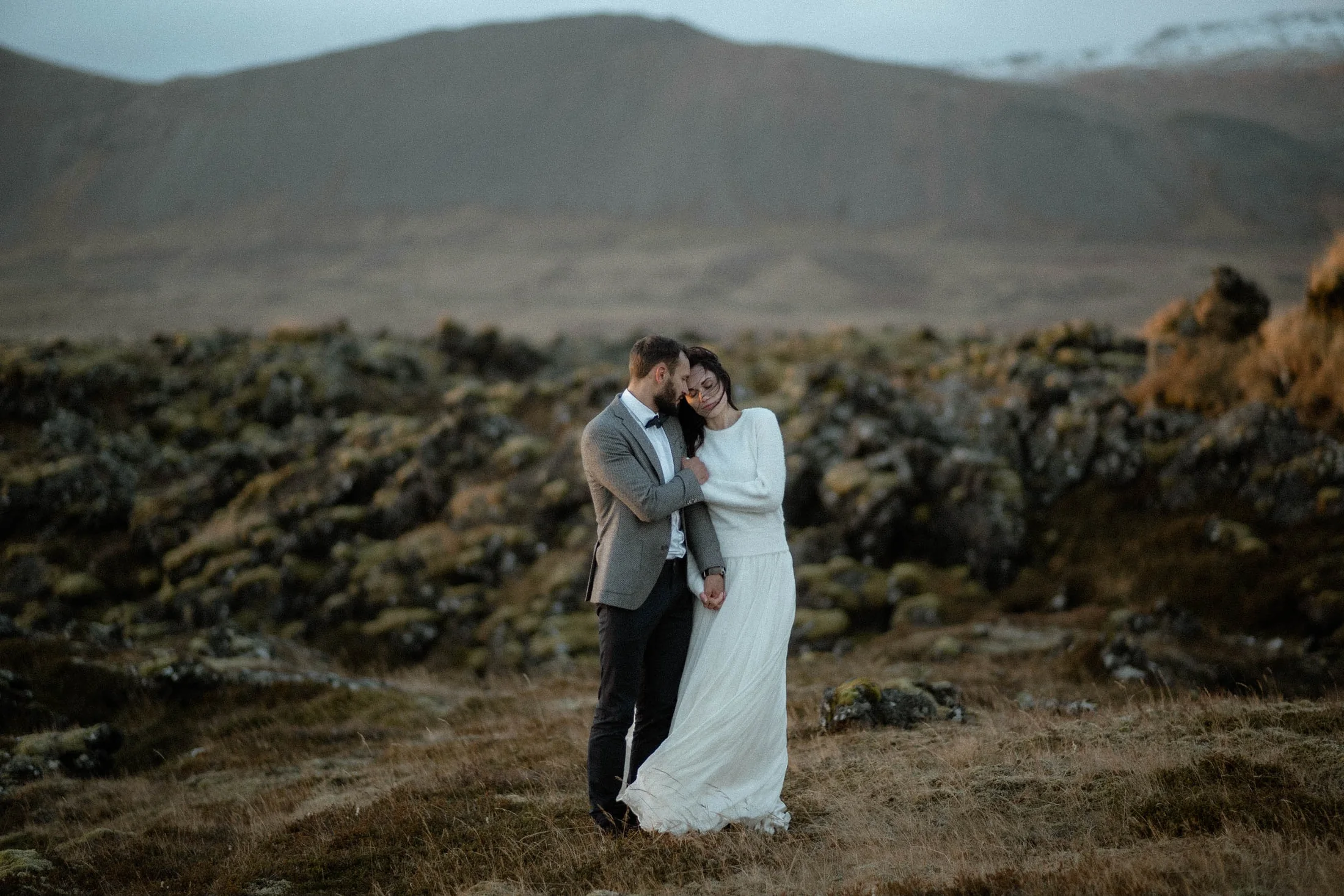 Couple walking below an Icelandic waterfall