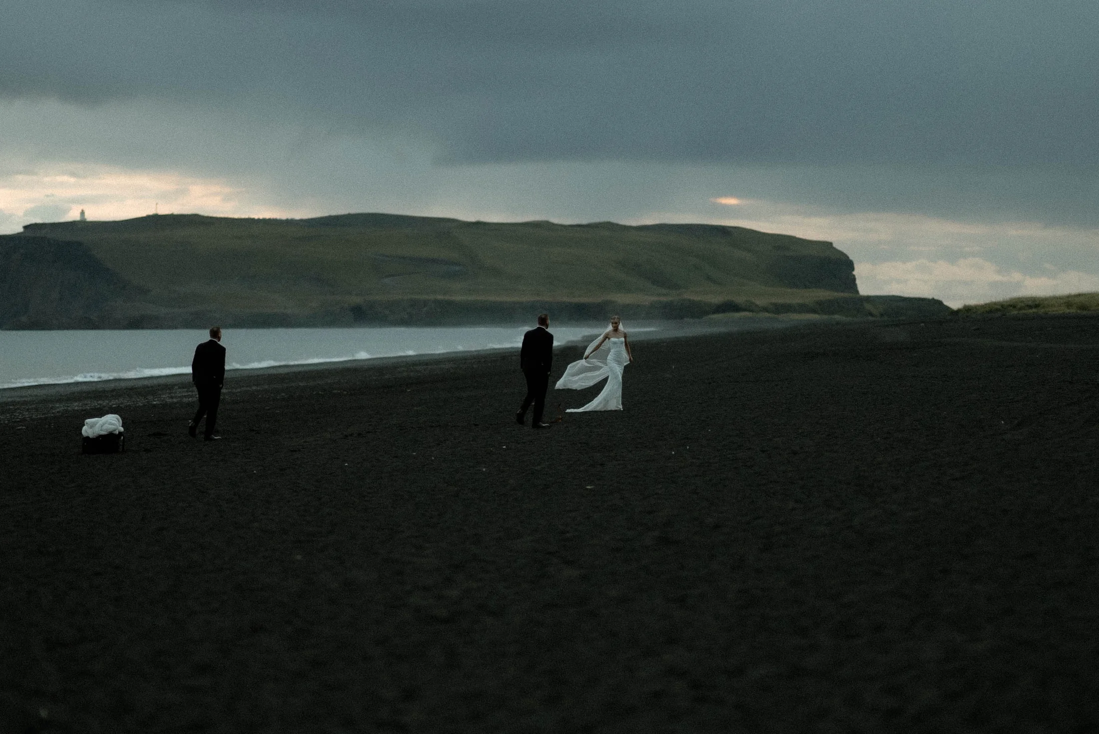 Couple crossing a black sand beach in Iceland